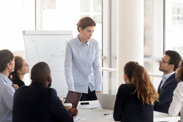 istock Serious female employee with flip chart at presentation. 1231521151