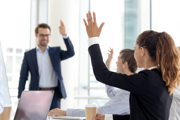 istock Young beautiful woman raise hand for question boss at presentation. 1231521261