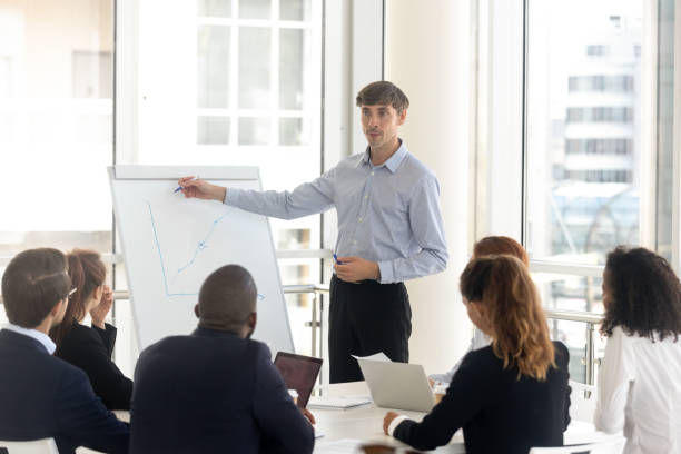 istock Male businessman draws graphs on flip chart at client presentation. 1231521417