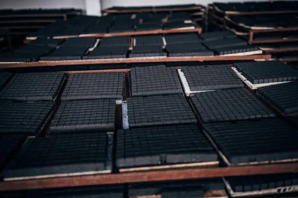 Coal for hookah on shelves in a row in factory, no people.