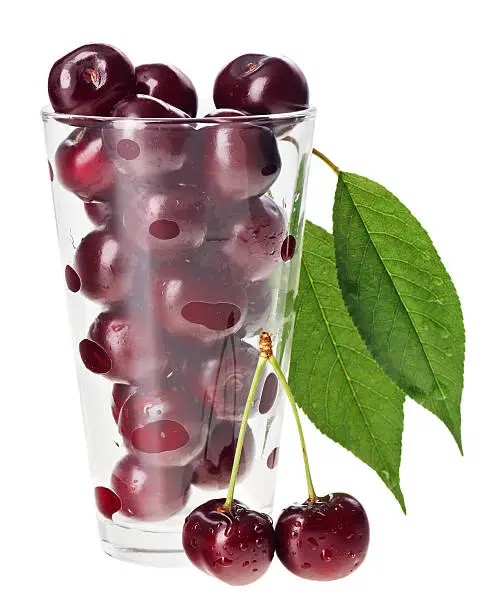 Red fresh wet cherry fruits in transparent glass, isolated on white