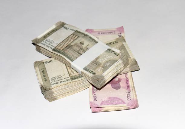 istock Bundles of five hundreds and two thousands indian currency notes on white background. 1231605057