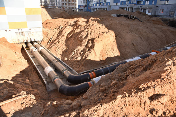 istock Laying heating pipes in a trench at construction site. Install underground storm systems of water main and sanitary sewer. Cold and hot water, heating and heating system of apartments in the house 1231607094