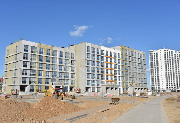istock Construction of a new multi-storey building. Suspended cradle for works insulation of the facade of the mineral wool. Modern residential building architecture. Housing renovation program 1231614708