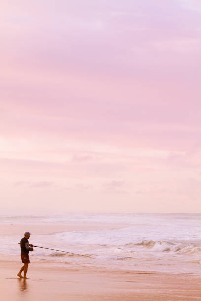 jeune homme volant à la mer avec l’horizon de côte d’or au coucher du soleil sur le dos. - q1 photos et images de collection