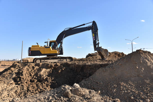istock Excavator working at construction site on earthworks. Backhoe digs ground for the foundation and for paving out sewer line. Construction machinery for excavating, loading, lifting and hauling of cargo 1231660235