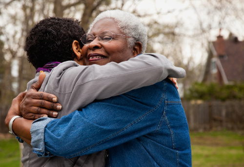 African American senior hugging her daughter photo