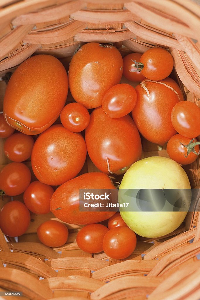 Plum and Heirloom Tomato Basket A basket of plum and heirloom tomatoes fresh off the vine. Aerial View Stock Photo