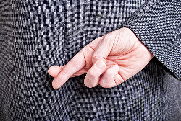 istock Man in a suit with his fingers crossed behind his back 123173514