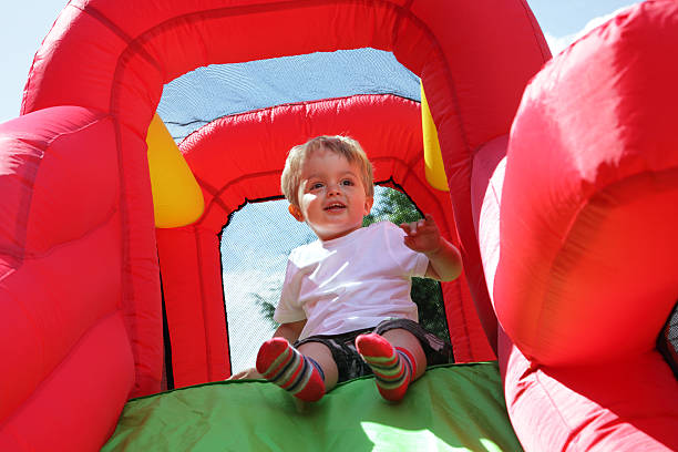 criança no castelo insuflável slide - inflatable child playground leisure games imagens e fotografias de stock