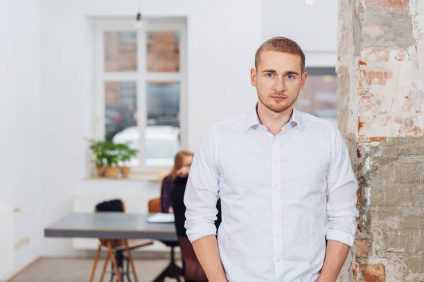 istock Serious young man in office with hands in pockets 1231784767