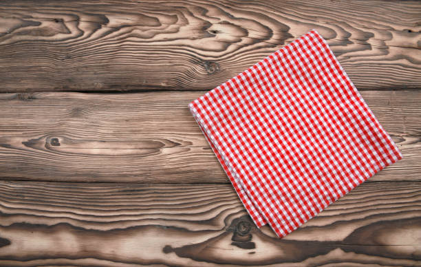 istock Red checkered kitchen cloth on dark wooden background,picnic towel folded on table top view. 1231794522