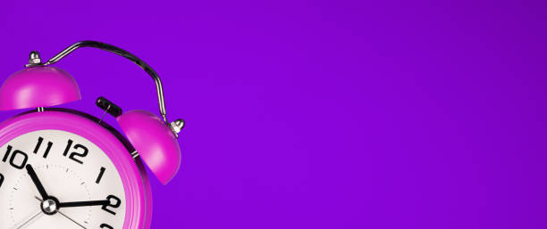 istock Retro pink alarm clock on purple background 1231803571
