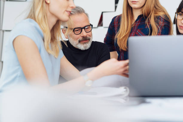 istock Group of business people working round a laptop 1231828008