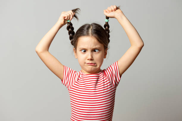 Squint Girl Six years old squint girl in gray background. making a face stock pictures, royalty-free photos & images