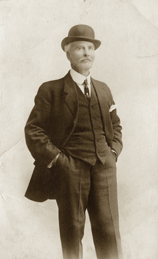 Early 1900 portrait of distinguished older man in suit & bowler hat. Original photo soft. Noise added.