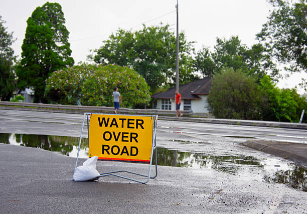 Water Over Road Sign  queensland floods stock pictures, royalty-free photos & images