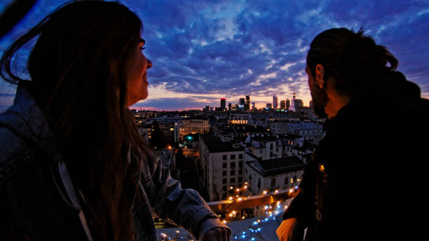 Night talks on illuminated rooftop. City after sunset