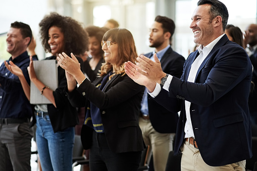 Shot of a group of businesspeople clapping during a conference