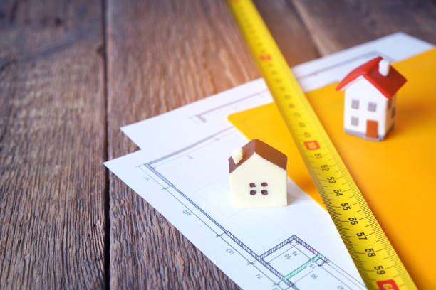 istock Architecture, building design and construction concept with building tape and building drawing in a folder on the wooden table. 1231875855