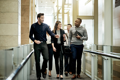 Shot of a group of businesspeople walking in a modern office