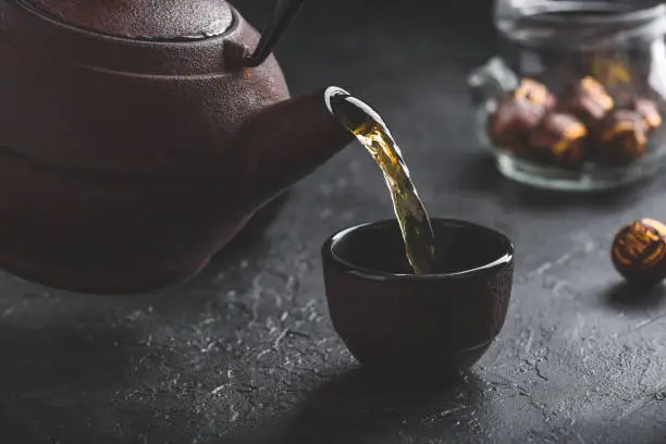 Photo of Pouring ready red tea into tea bowl