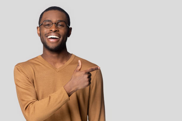 istock Isolated on grey African guy point finger sideways at copyspace 1231953823