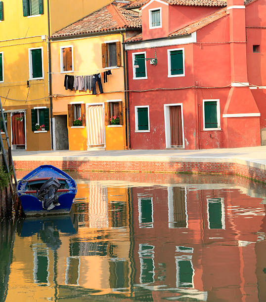 Burano island canal, colorful houses and boats in the Venice lagoon. Italy, Europe.