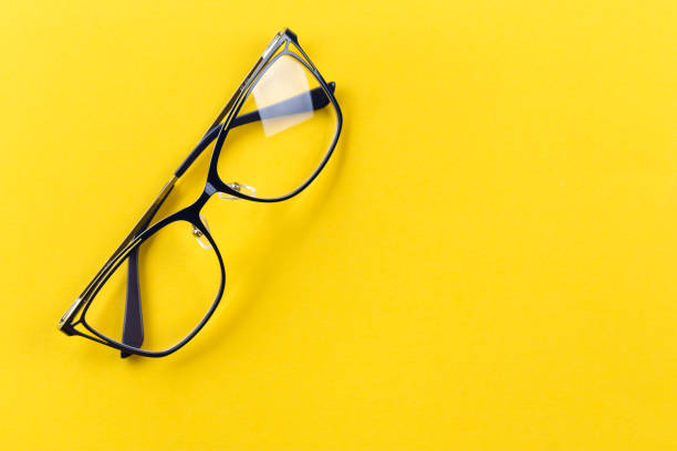 transparent glasses for vision with black arms on a bright yellow background