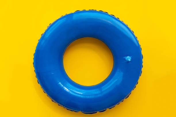 vorderansicht des blauen gummirings für schwimmbad auf gelbem hintergrund. ansicht von oben - swim ring stock-fotos und bilder