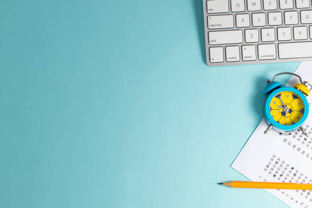 istock Take the exam, write the exam. Exam paper with alarm clock on blue background, top view copy space 1232004868