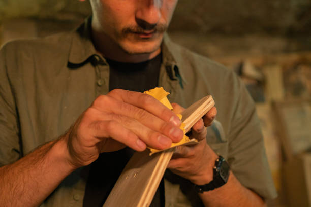 istock A carpenter using a sandpaper to smooth out the edge of a skateboard 1232006420