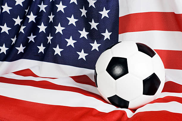 cubierta bandera estadounidense tiene una pelota de fútbol - american football football focus on foreground team sport fotografías e imágenes de stock