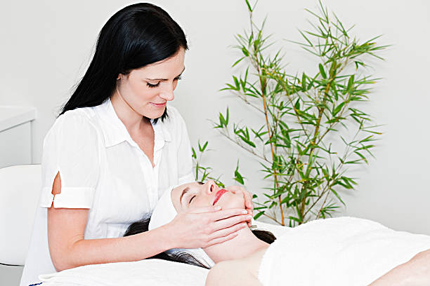 косметолога придает массаж лица - spa treatment health spa zen like bamboo стоковые фото и изображения