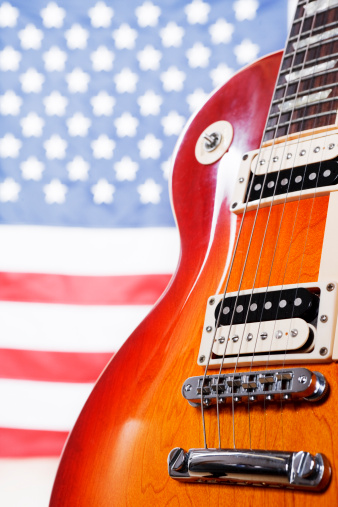 Close up of body of classic American electric guitar shot against American flag. Shot with Canon EOS 1Ds Mark III.