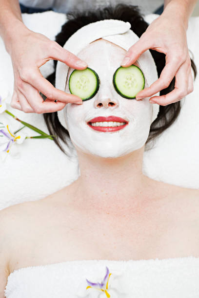 istock Beauty therapist places cucumber slices on eyes 123201280