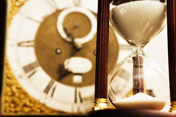 istock Vintage hourglass with antique clock face in background 123201547