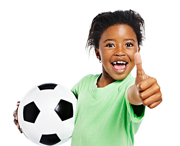 piccola ragazza africana con pallone da calcio ti trionfante pollice in alto. - capelli cotonati foto e immagini stock
