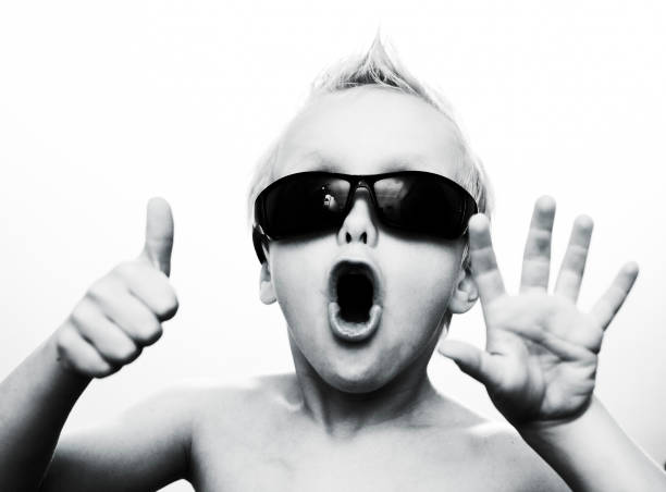 Rock star kid Young dude snapped by the paparazzi. Retro film-style treatment. Authentic sampled film grain added. Camera: Canon EOS 1Ds Mark III. 6 7 years stock pictures, royalty-free photos & images