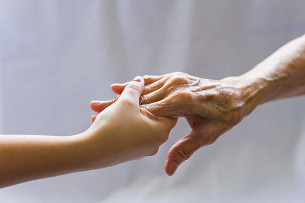 istock Younger hand holding on to older person's hand 123203511