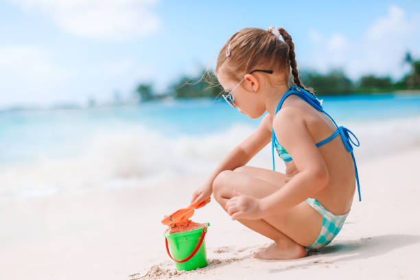 istock Little girl at tropical white beach making sand castle 1232039170
