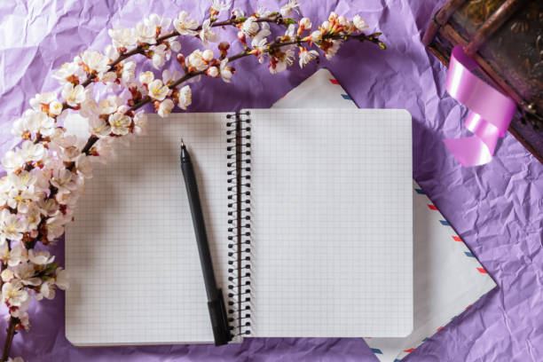 istock Open blank notebook, pen and cherry blossoming branch on bright background. Writing letters, correspondence concept 1232039679