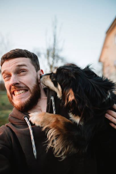 istock A young man plays with a dog and takes a selfie 1232088845