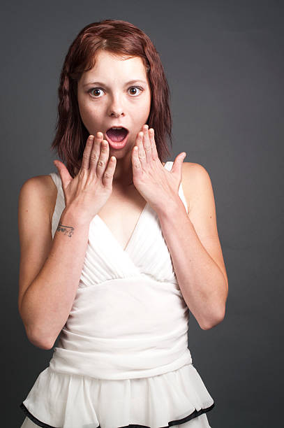 Surprised girl in white dress. stock photo