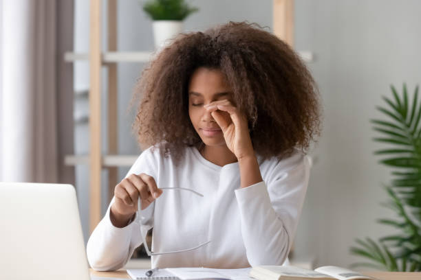 ragazza adolescente africana che si strofina gli occhi stanchi dal computer che tiene gli occhiali - young male immagine foto e immagini stock