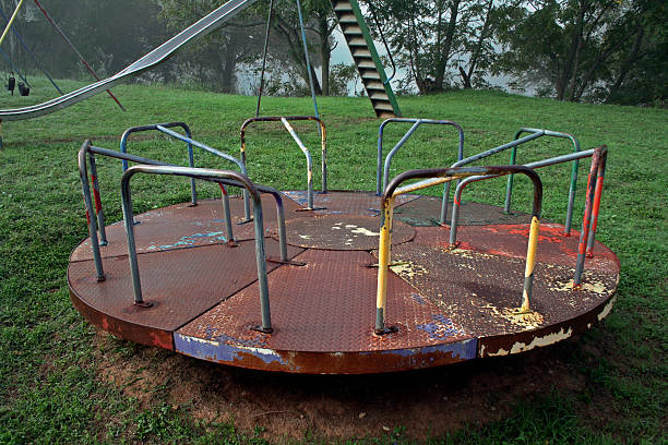 abandoned playground carousel stock photo