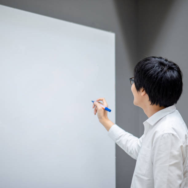 istock Asian man teacher writing on blank whiteboard 1232233571