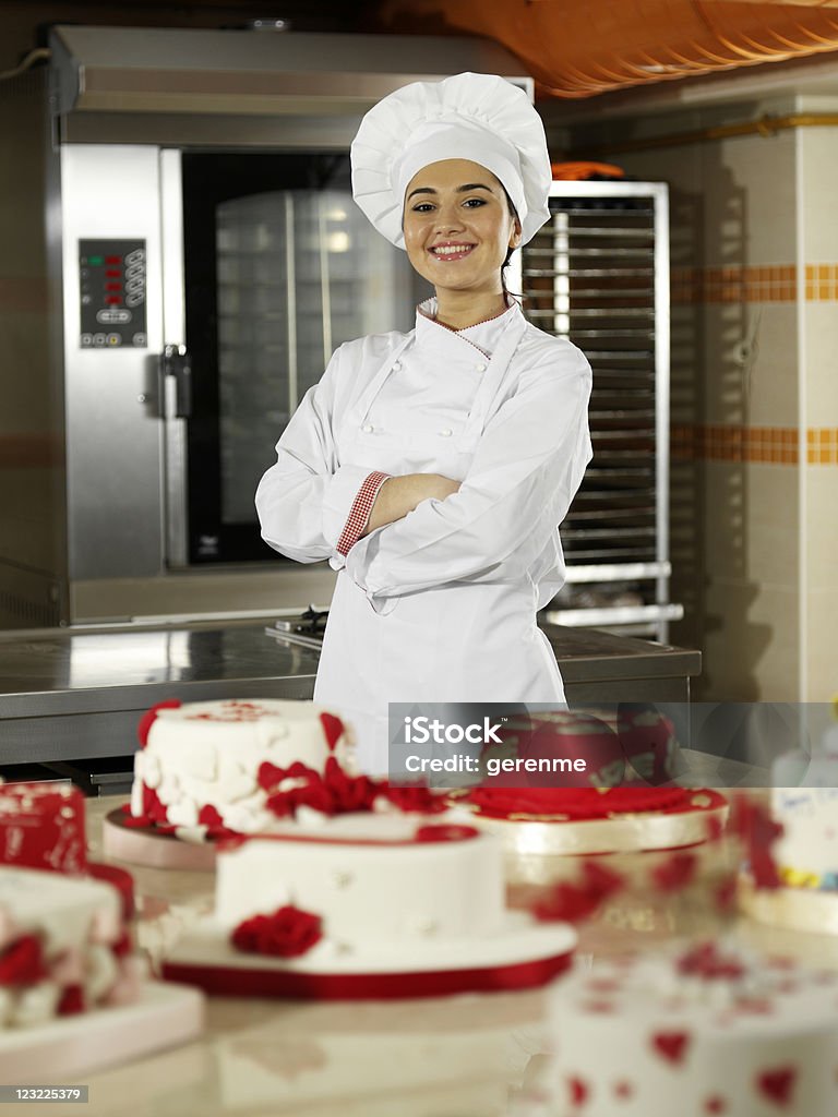 Femmina chef mostrando torte - Foto stock royalty-free di Abito da cuoco