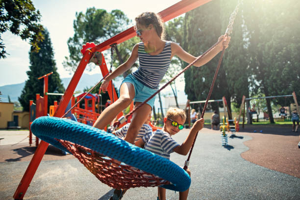 Kids swinging together on a big swing Three kids lying on a big swing and having fun.
Nikon D850 swing play equipment stock pictures, royalty-free photos & images