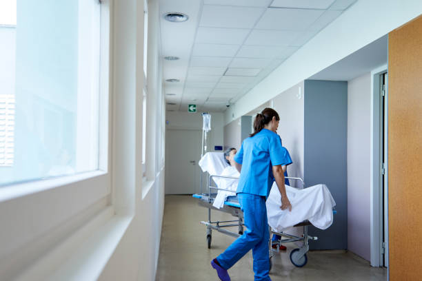 istock Two nurses move a patient on a hospital gurney. 1232295541